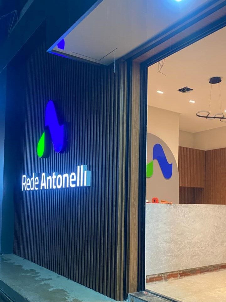 Comunicação visual interna e logotipo em relevo na recepção da Rede Antonelli